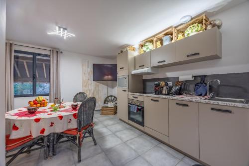 a kitchen with a table and a kitchen with white cabinets at LOGIS DU GRAND PIN in Saint-Martin-des-Entrées