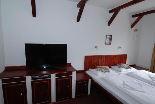 a room with two beds and a flat screen tv at Rodinný "Hotel U Můstků" in Desná
