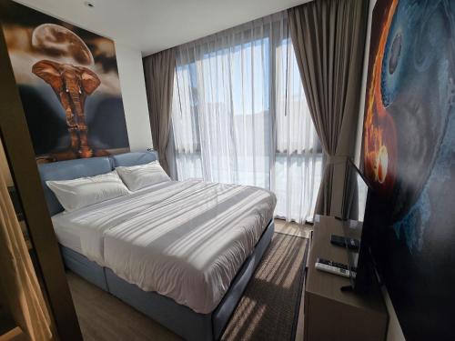 a bedroom with a bed and a large window at EDGE Central Pattaya 2bdrm Balcony View in Pattaya Central
