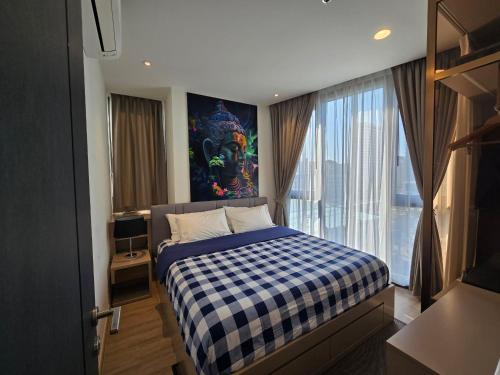a bedroom with a bed with a blue and white checked blanket at EDGE Central Pattaya 2bdrm Balcony View in Pattaya Central