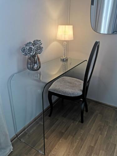 a glass table with a chair and a lamp at A Flor da Rosa in Vila Nova de Foz Coa