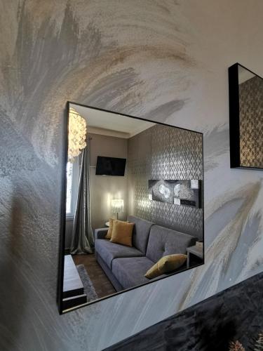 a mirror on a wall with a couch in a living room at A Flor da Rosa in Vila Nova de Foz Coa