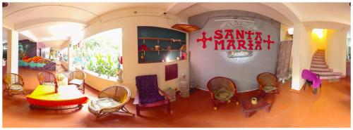 a room with chairs and a sign that reads a santa martacist at Santa Maria Hostel Kovalam in Kovalam