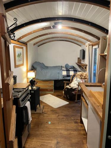 a room with a bed and a room with a kitchen at The carriage in Three Cocks Junction