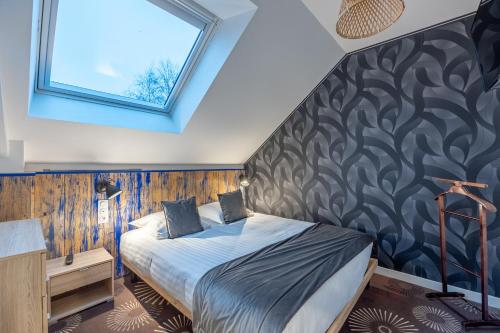 a bedroom with a bed with a black and white wall at LOGIS DU GRAND PIN in Saint-Martin-des-Entrées
