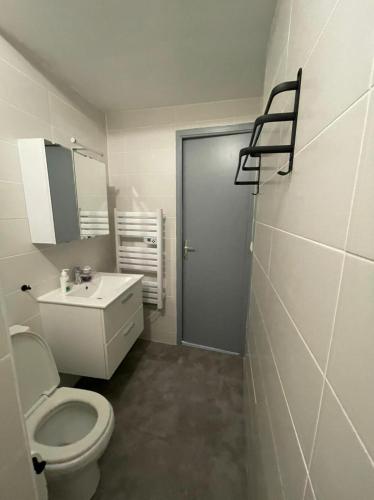 une salle de bain blanche avec des toilettes et un lavabo dans l'établissement Le Nid de Liais, à Cherbourg en Cotentin