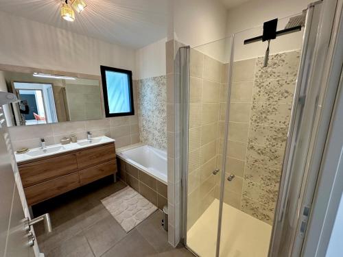 a bathroom with a shower and a tub and a sink at Villa Provençale in Le Thor