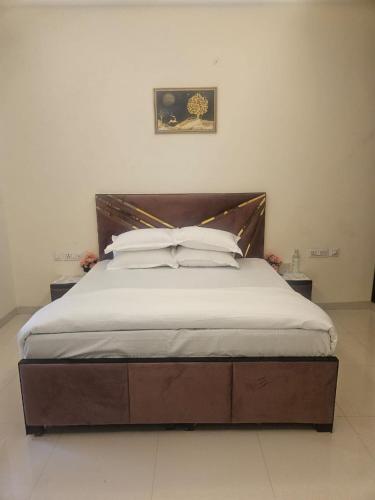 a large bed with a wooden headboard in a bedroom at Ashirwaad 249 in Greater Noida