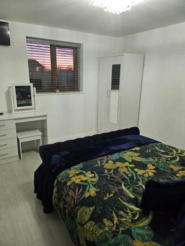 a bedroom with a bed and a desk and a television at Brooke View Barns No2 in Norwich