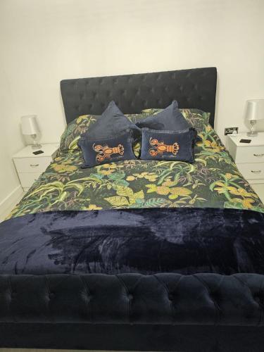 a bed with a black headboard and pillows on it at Brooke View Barns No2 in Norwich