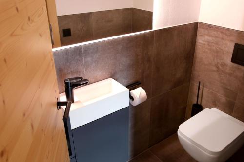 a bathroom with a sink and a toilet at Haus MUMO in Bad Hofgastein
