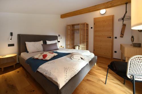a bedroom with a large bed and a wooden floor at Haus MUMO in Bad Hofgastein