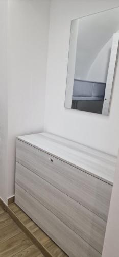 a dresser in a white room with a mirror at Campanile 17 in Manfredonia