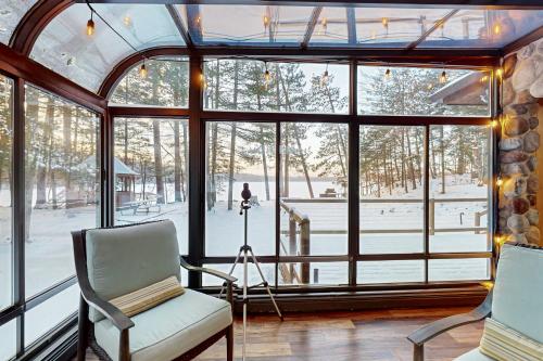 a room with a window with two chairs and a camera at Good Time Inn in Lake Tomahawk