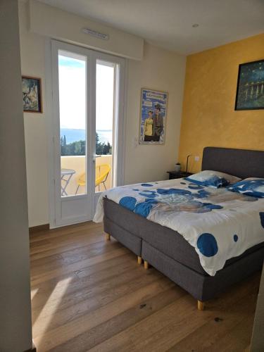 une chambre avec un lit et une porte coulissante en verre dans l'établissement Résidence Le Château - Parc Santa Lucia, à Saint-Raphaël