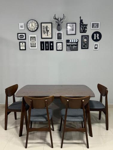 a dining room table with chairs and a wall with pictures at Simply Staycation Palm Garden in Lahad Datu