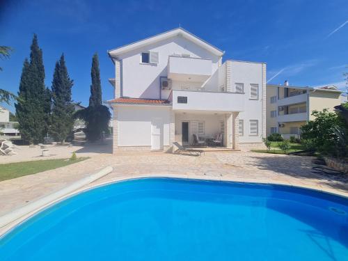 eine Villa mit einem Swimmingpool vor einem Haus in der Unterkunft Villa Mali San in Trogir