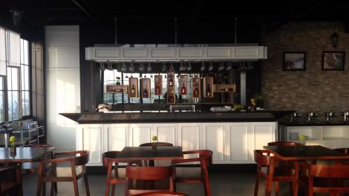 a restaurant with tables and chairs and a bar at Green Eden Hotel in Manado