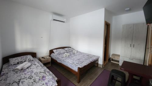 a small bedroom with two beds and a desk at Kuća sa lepim pogledom - porodica Čolović in Rudno