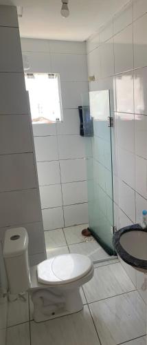 a bathroom with a toilet and a shower and a sink at Casa do hóspede in Balneário Camboriú