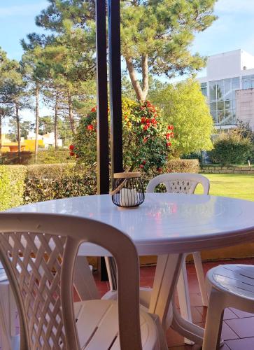 a table and chairs on a porch with a view of a park at Villas Terrace Apartment in Praia de Mira