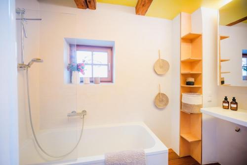 une salle de bain blanche avec une baignoire et une douche dans l'établissement Historisches Cottage in der Altstadt - für 6 Gäste, à Bad Tölz