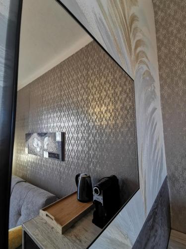 a mirror on a wall next to a bed at A Flor da Rosa in Vila Nova de Foz Coa