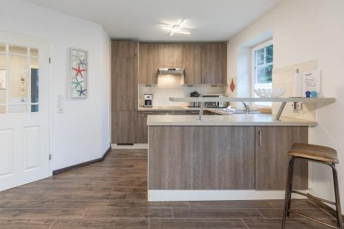 a kitchen with wooden cabinets and a counter top at Windrose in Drelsdorf
