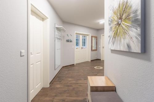 a hallway with white walls and a wooden bench at Windrose in Drelsdorf