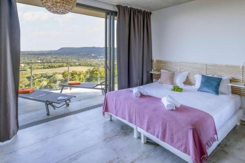 une chambre avec un grand lit et un balcon dans l'établissement family villa, beautiful open sea view & scrubland, à Conca