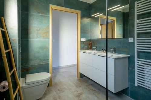 une salle de bain avec toilettes, lavabo et miroir dans l'établissement family villa, beautiful open sea view & scrubland, à Conca