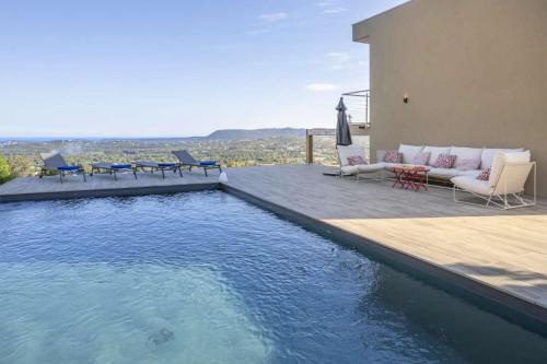 - une piscine avec un canapé et des chaises à côté d'une maison dans l'établissement family villa, beautiful open sea view & scrubland, à Conca