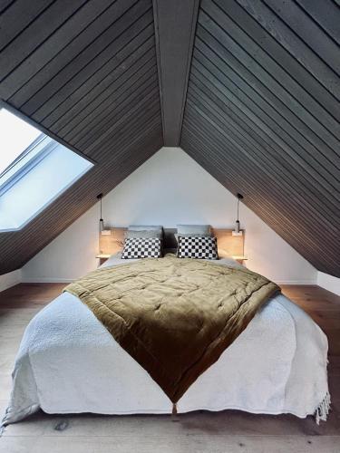 a bedroom with a large bed in a attic at Toi-t et moi, Charming penthouse, view et nature in Malmedy