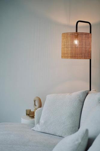 a bed with a pillow and a lamp in a room at Toi-t et moi, Charming penthouse, view et nature in Malmedy