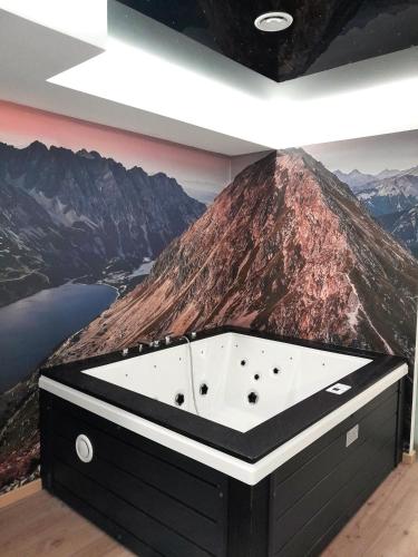 a bathroom with a mountain mural on the wall at Apartament w Tucholi in Tuchola