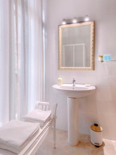 a white bathroom with a sink and a mirror at Hostal Antigua Morellana in Valencia