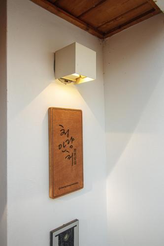 a light on a wall with a sign on it at Cheongryang-Anchae 2BR 2BA Hanok Spa Free Parking in Seoul
