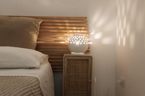 una lámpara sentada en una mesita de noche junto a una cama en Bari Vecchia Suite, en Bari