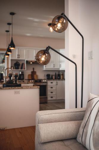 a living room with a couch and a lamp at Villa Experience Nature Le Nid in Saint-Irénée