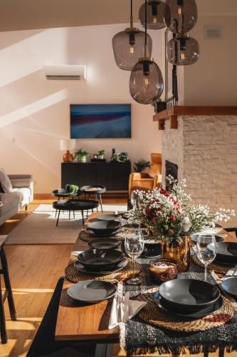 a dining room with a table with plates and wine glasses at Villa Experience Nature Le Nid in Saint-Irénée