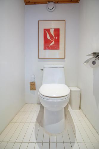a bathroom with a toilet and a picture on the wall at Cheongryang-Anchae 2BR 2BA Hanok Spa Free Parking in Seoul