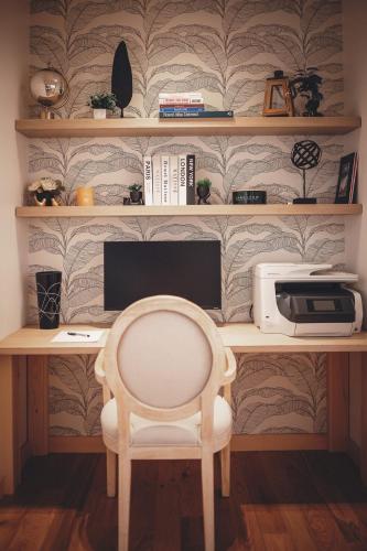 a desk with a computer monitor and a chair at Villa Experience Nature Le Nid in Saint-Irénée