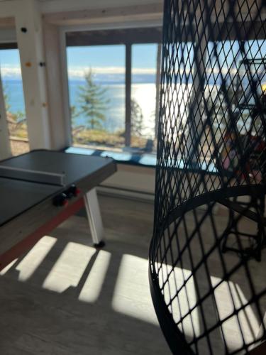a ping pong table in a room with a view of the ocean at Villa Experience Nature Le Nid in Saint-Irénée