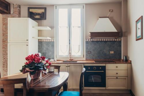 une cuisine avec une table avec un vase de fleurs dans l'établissement B&B Formigola, à Corticelle Pieve