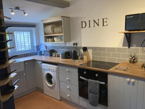 a kitchen with a washer and dryer in it at Witcroft Cottage in Pershore