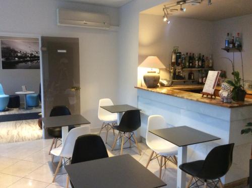 a restaurant with tables and chairs and a counter at Bristol Logis Cit'Hotel Périgueux Centre in Périgueux