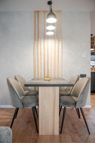 a dining room table with chairs and a light fixture at Golden Wood in Sovata