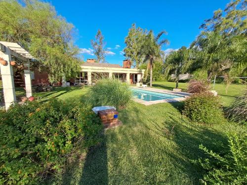 una casa con piscina en un patio en QUINTA LA ESTELA, en Pilar