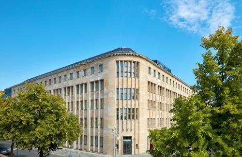 ein großes Backsteingebäude mit Bäumen davor in der Unterkunft Hotel Berlin Potsdamer Platz by Leonardo Hotels in Berlin