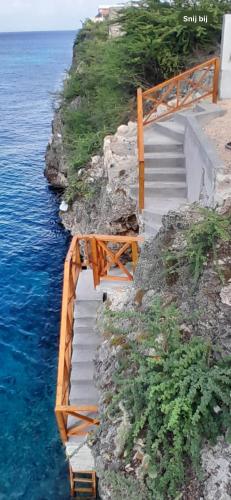 a set of stairs on a cliff next to the water at New villa Caribbean Pearl in Willemstad